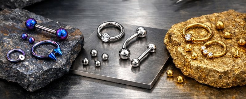 Joias de piercing em titânio dispostas num tabuleiro