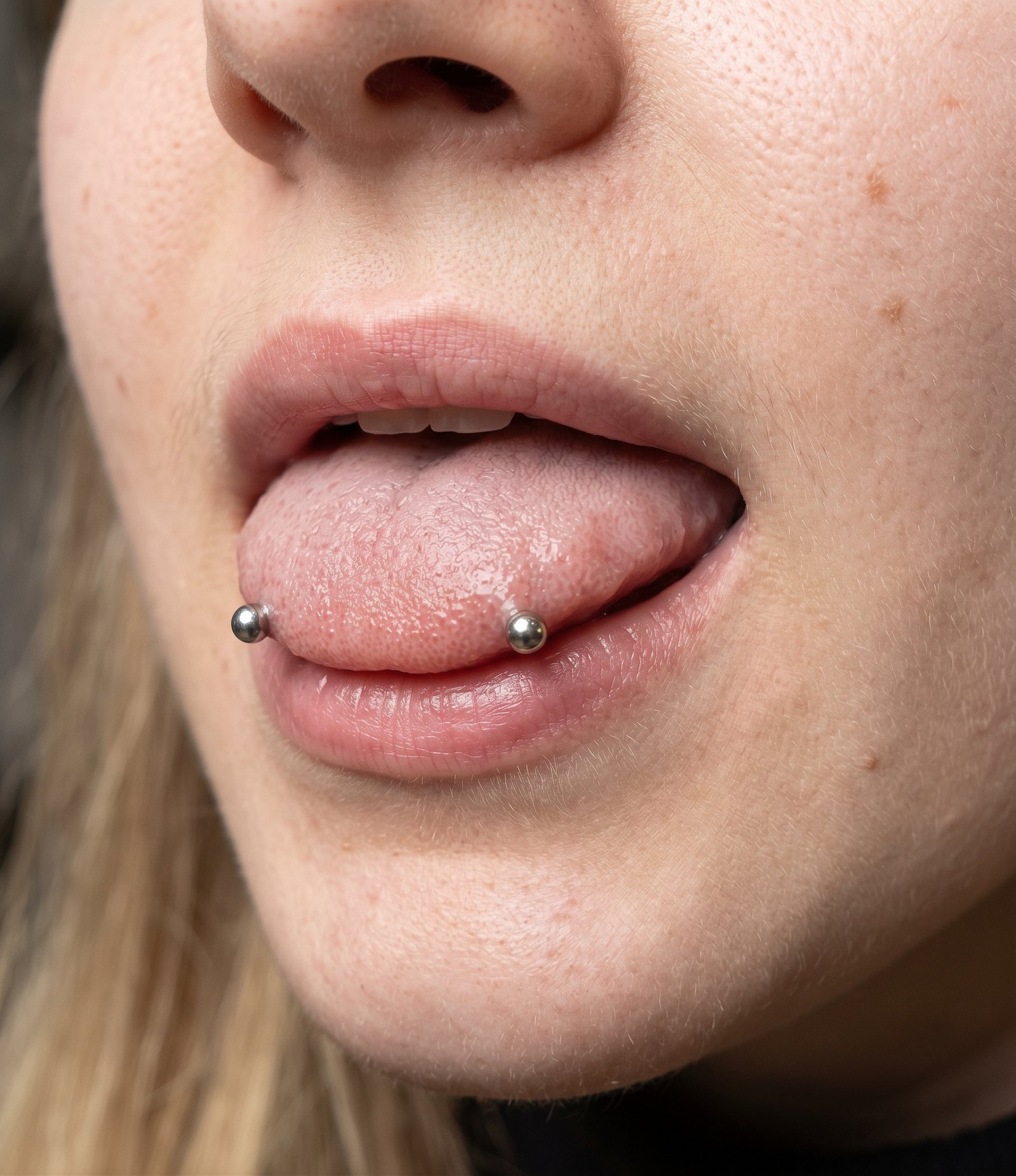 Piercing horizontal Snake Eyes, com dois terminais junto aos lados da ponta da língua