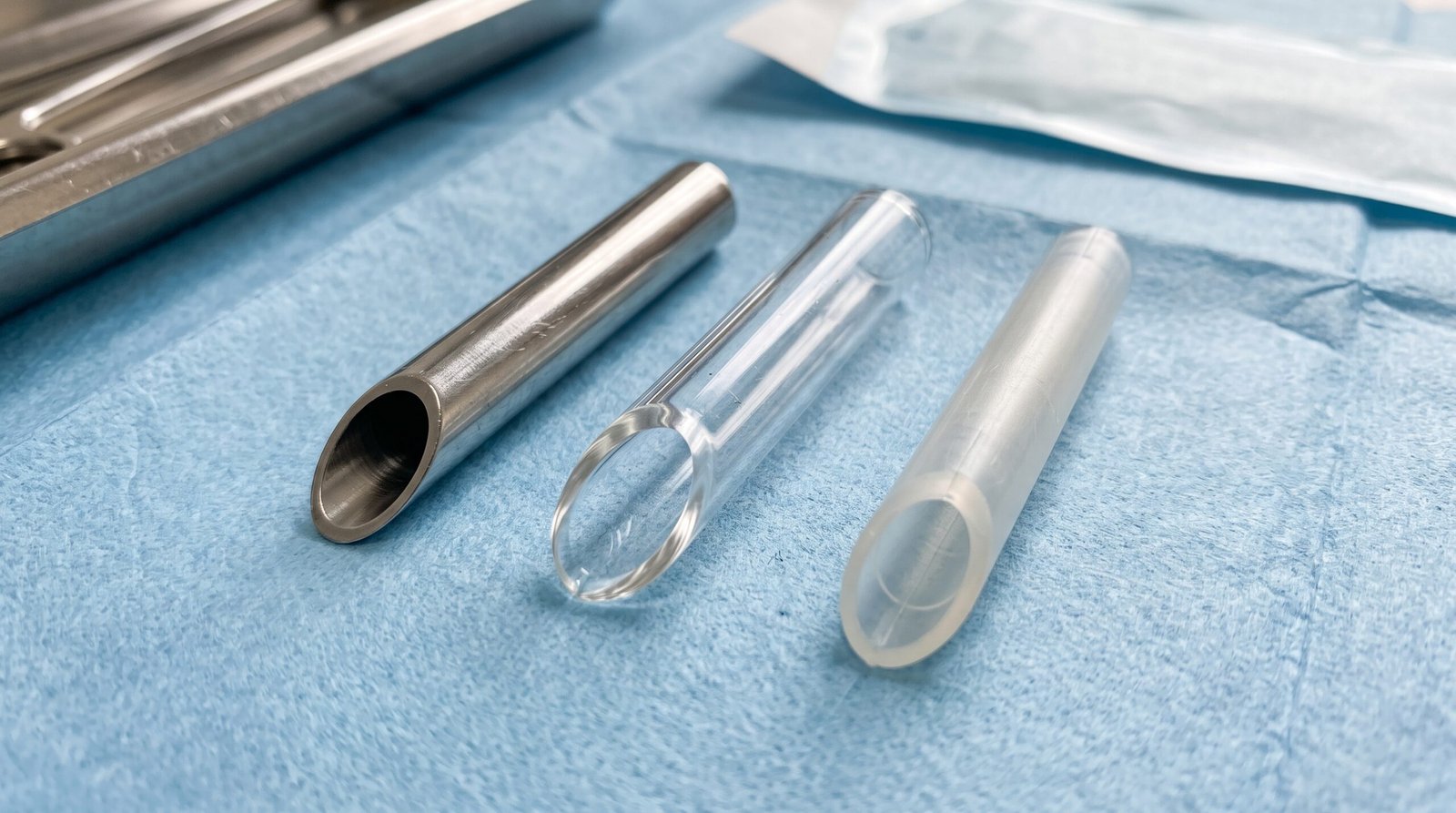 Receiving tube in acciaio, vetro e materiale plastico su un telo azzurro.